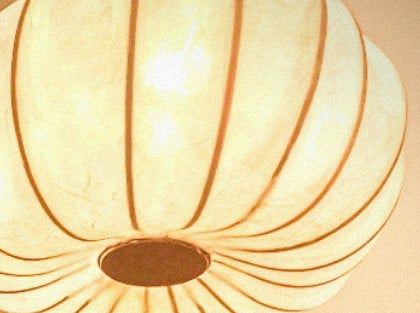 “Turban” is a suspended sculptural light piece, shaped in soft, rounded folds that evoke the wrapped structure of a traditional turban. Hanging from the ceiling, it emits a warm and diffused glow — an intimate gesture of form and light above the bedside. Materials: Handmade paper, bamboo, fabric-covered electrical wire, porcelain light socket Dimensions: Ø 30 × 20 cm